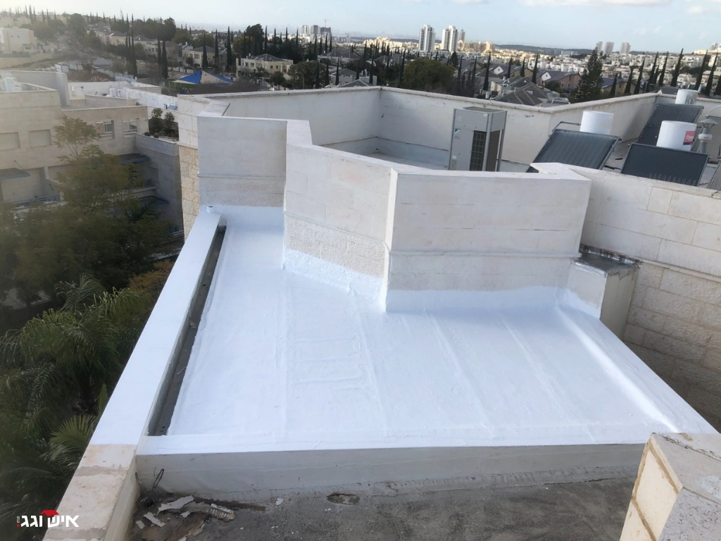 מבט על גג שטוח לאחר איטום לבן עם מזגנים מותקנים בשטח